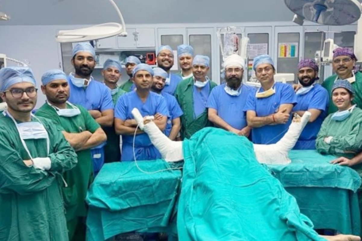 Sala de cirurgia com médicos e paciente deitado em maca após transplante