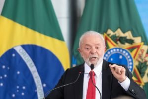 Imagem colorida do presidente Lula, no Planalto, em frente à bandeira do Brasil Bolsonaro - Metrópoles