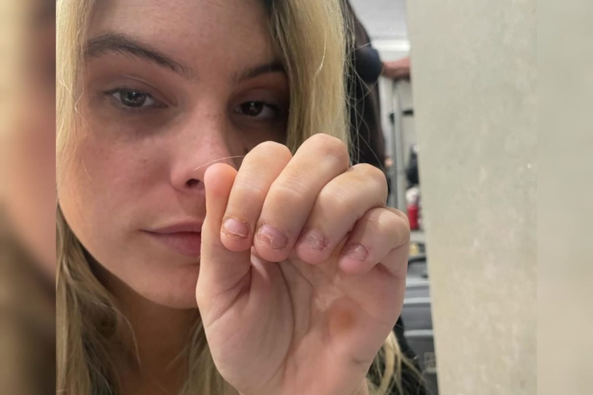 Foto mostra a influenciadora Lele Pons em segundo plano, mostrando suas unhas para a câmera