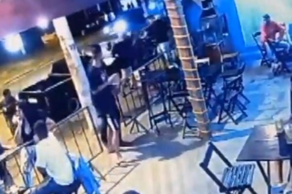 Imagem colorida de câmera de segurança mostra grupo de pessoas discutindo na frente de um bar; uma mulher e o dono do bar foram mortos a tiros - Metrópoles