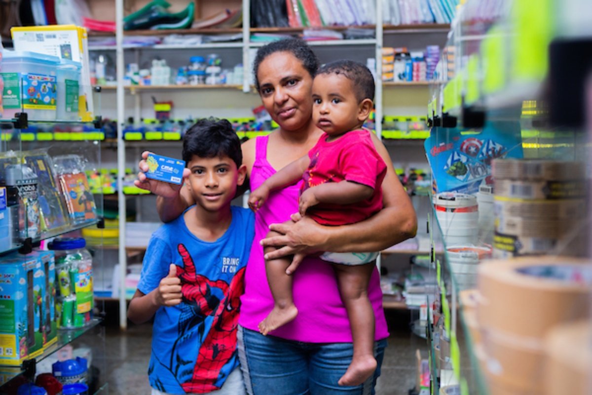 Fotografia colorida de uma mãe com dois filhos