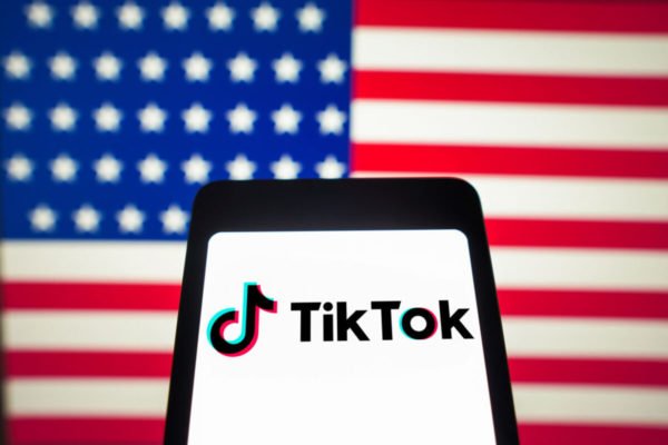 Logo do TikTok na frente da bandeira dos Estados Unidos - Metrópoles