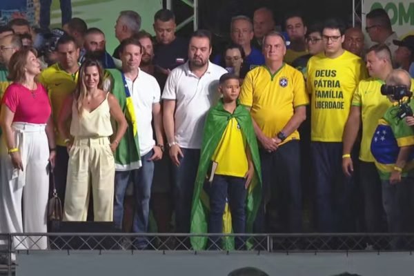 Imagem colorida de Alexandre Ramagem (de branco com a bandeira do Brasil), Jair Bolsonaro (com a camias da Seleção) e Cláudio Castro (de branco) - Metrópoles