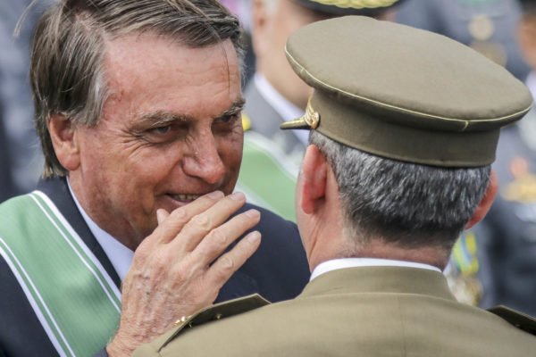 Ex-presidente jair Bolsonaro fala no ouvido de militar das forças armadas - metrópoles
