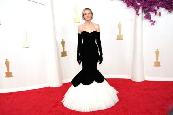 Carey Mulligan no tapete vermelho do Oscar 2024 usando vestido preto e branco com luvas - Metrópoles