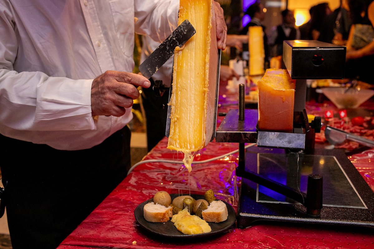 Raclette, queijo suíço derretido, servido sobre petiscos variados