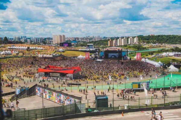 Imagem colorida do festival Lollapalooza, com um grande público em volta de um palco - Metrópoles