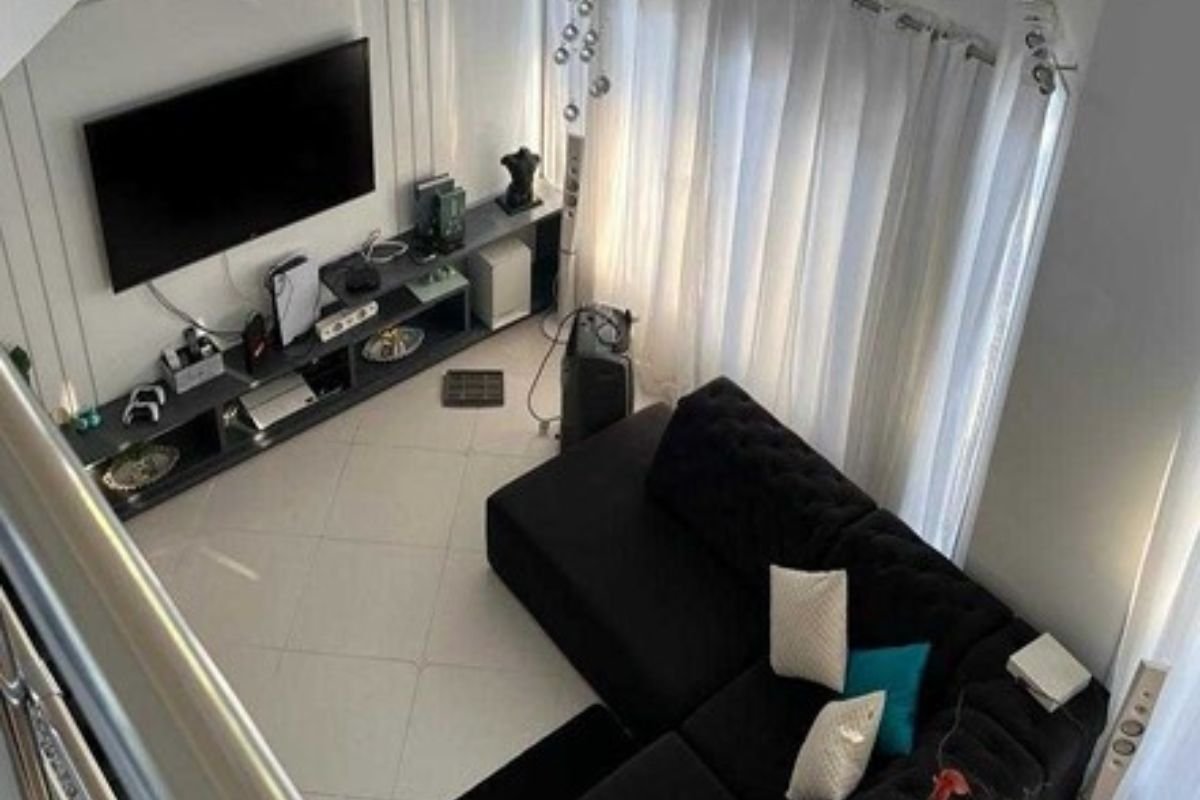 Imagem colorida de sala de estar da Japa do PCC. Foto mostra vista de cima de sofás e TV - Metrópoles