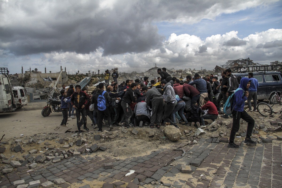 Palestinos correm para a costa depois que ajuda humanitária caiu do ar