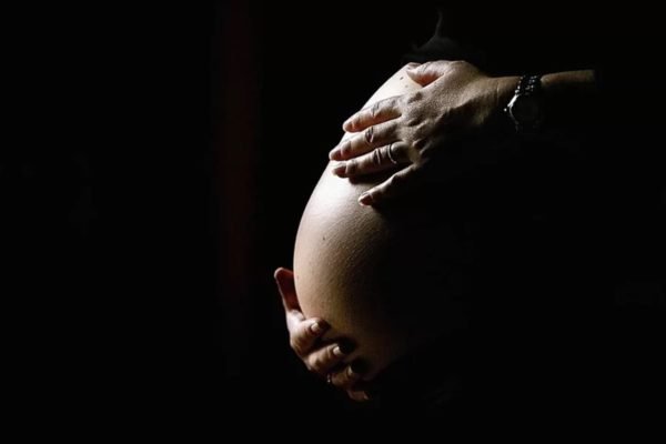 Imagem colorida de barriga de pessoa durante gravidez bebê - Metrópoles