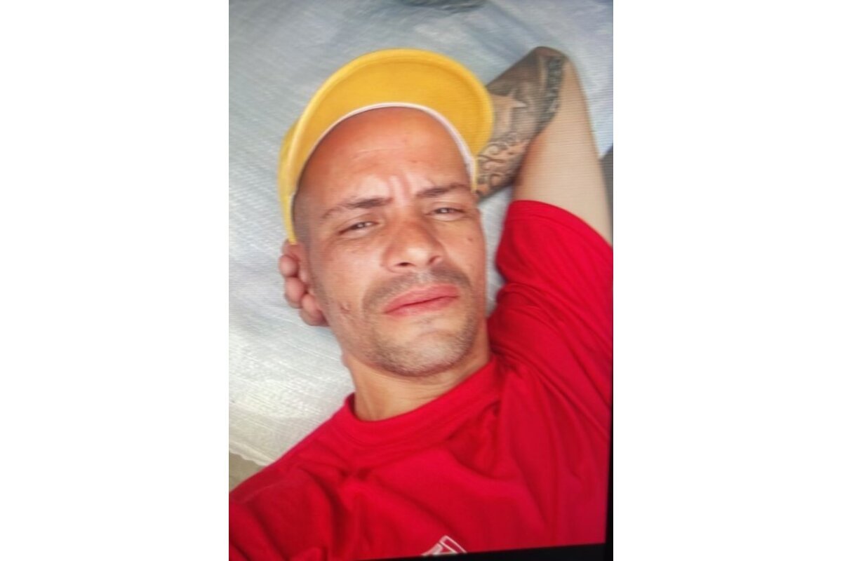 Foto colorida de homem de boné amarelo, com cabeça apoiada no antebraço esquerdo - Metrópoles