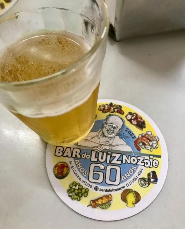 foto colorida de detalhe de copo de chopp com bolacha do bar do Luiz Nozoie, em SP - Metrópoles