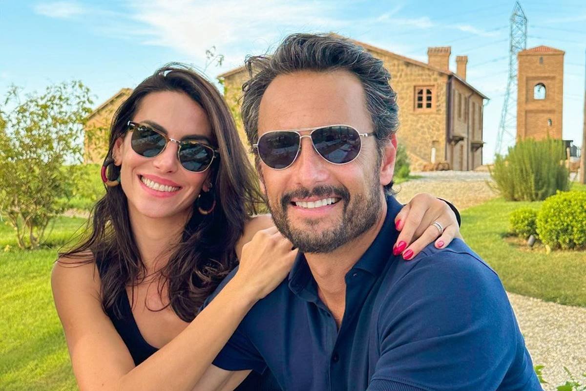 Foto colorida mostram homem e mulher sorrindo, abraçados e ambos usam óculos de sol - Metrópoles