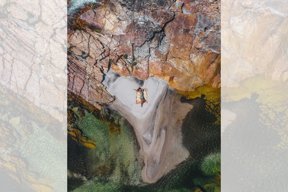 Foto colorida de uma mulher na cachoeira - Metrópoles