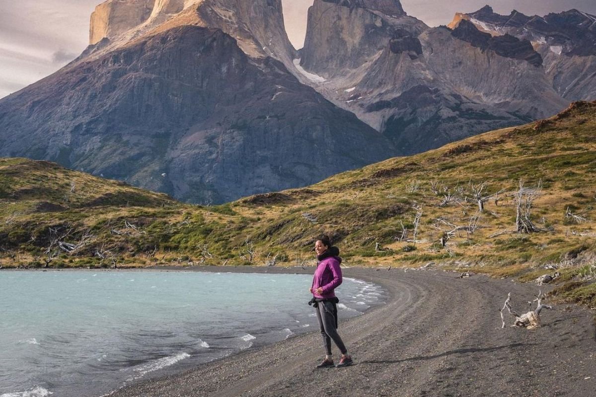 Foto colorida de uma mulher em frente ao lago - Metrópoles