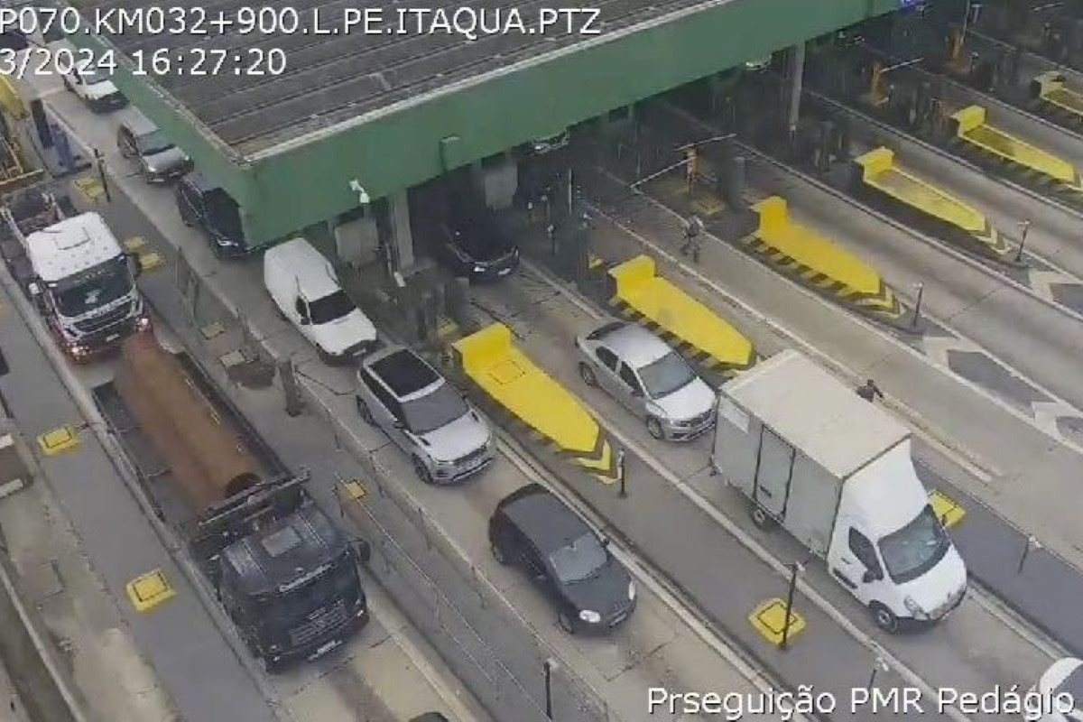 Imagem colorida de visão aérea de carros passando em pedágio. Metrópoles