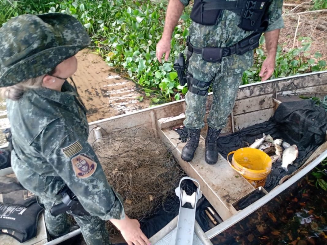 foto colorida de flagrante da Polícia Ambiental de pescador multado por pesca irregular no Rio Paraná, em Panorama (SP) - Metrópoles