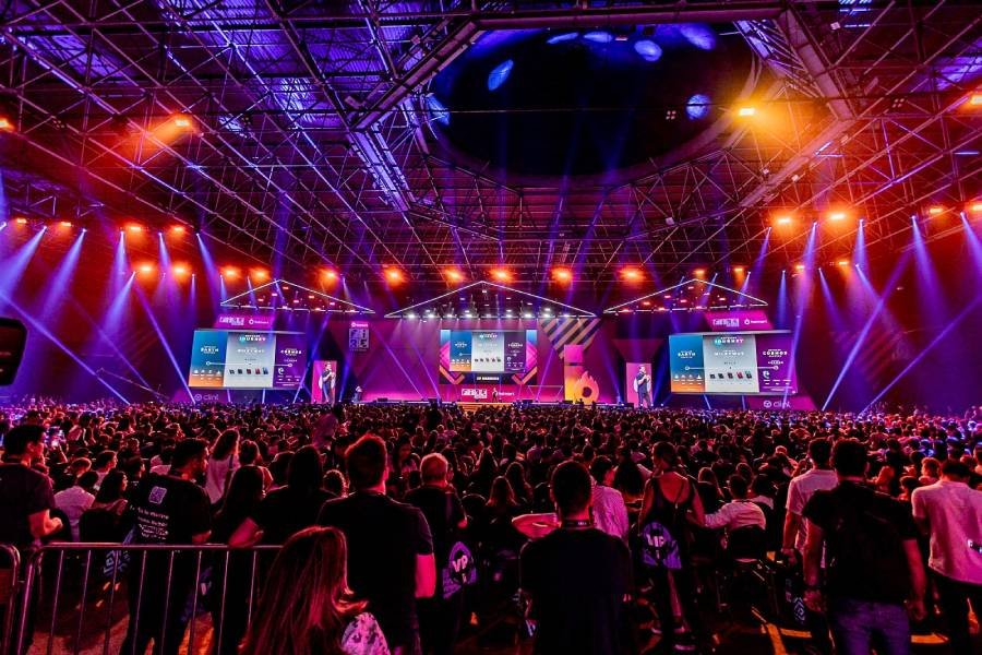 Fotografia colorida mostrando palestra em palco dentro de auditório cheio de pessoas-Metrópoles