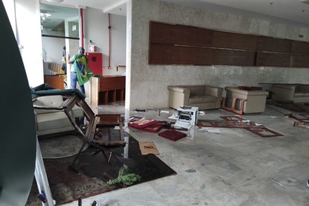 Manifestantes bolsonaristas invadem e destroem o prédio do Supremo Tribunal Federal (STF). Os terroristas andam pela parte de dentro do prédio, jogando móveis no chão e quebrando vidraças. Muitos escombros aparecem destroçados - Metrópoles