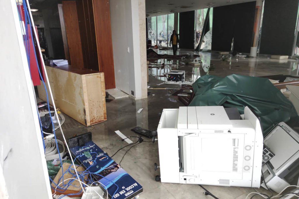 Manifestantes bolsonaristas invadem e destroem o prédio do Supremo Tribunal Federal (STF). Os terroristas andam pela parte de dentro do prédio, jogando móveis no chão e quebrando vidraças. Muitos escombros aparecem destroçados - Metrópoles