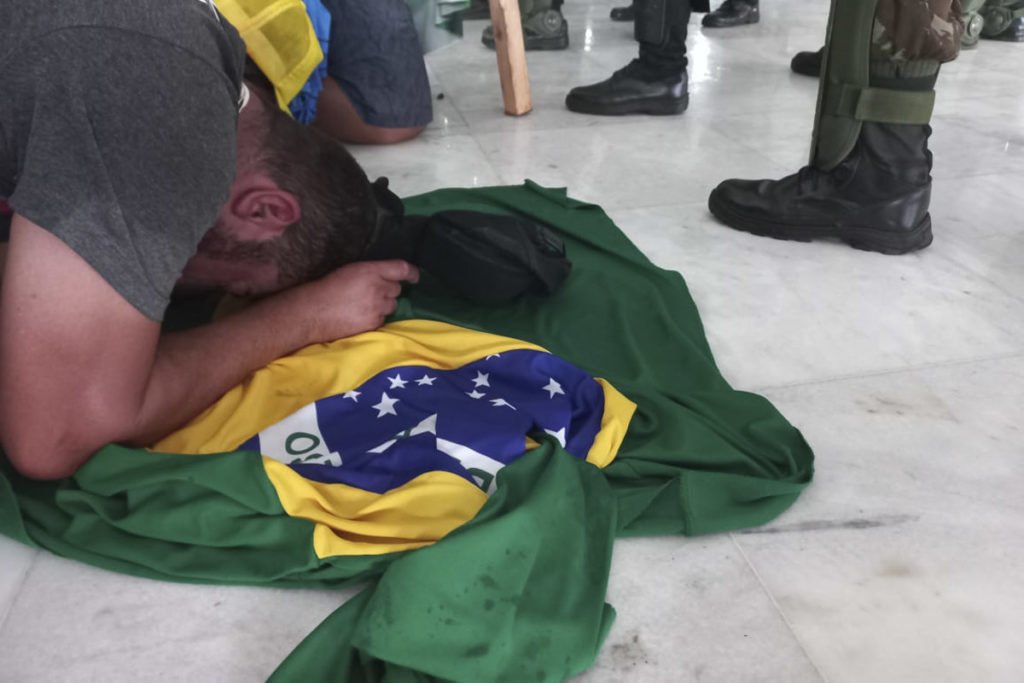 Bolsonarista chora em cima de bandeira _ Metrópoles