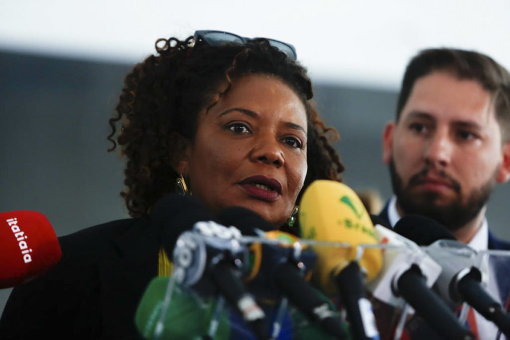 Ministra da Cultura, Margareth Menezes, concede entrevista coletiva no Palácio do Planalto para falar sobre destruição de patrimônio público causada por terroristas bolsonaristas. Ela fala diante de microfones e cercada de autoridades - Metrópoles