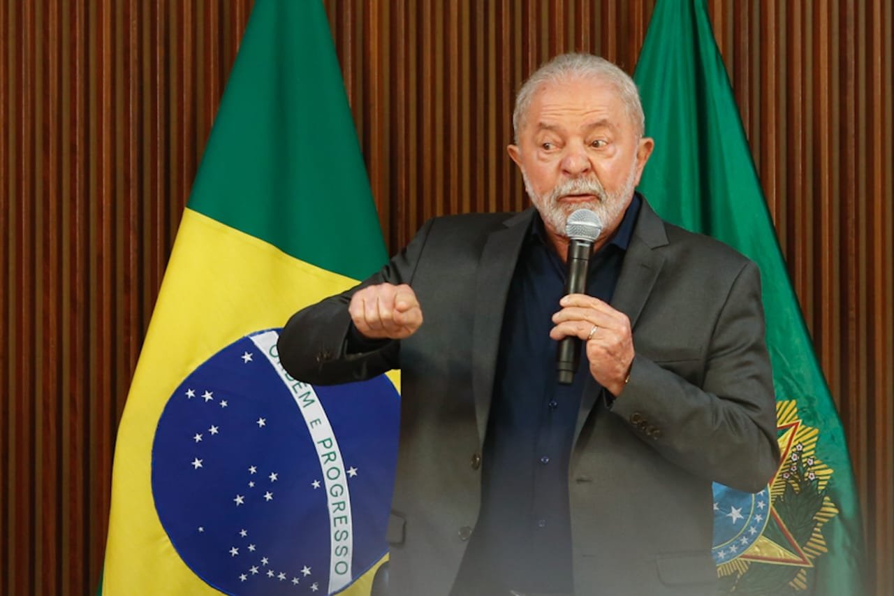 Lula se reúne com governadores no Palácio do Planalto após atos terroristas promovidos por bolsonaristas. Ele fala em microfone e gesticula com bandeira do Brasil atrás - Metrópoles