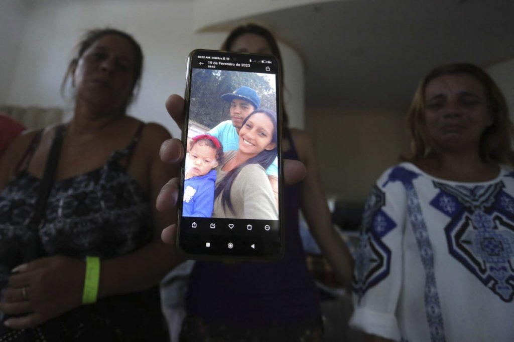 Familiares seguram celular com foto da vítima das chuvas em são Paulo - Metrópoles