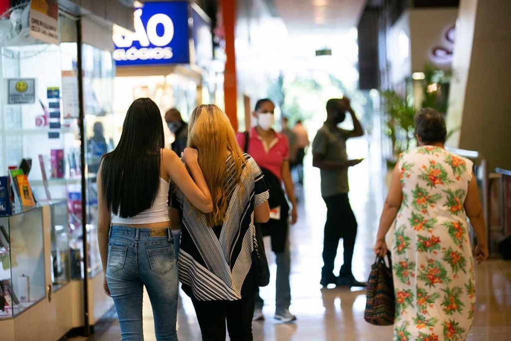 Pessoas caminham em centro comercial